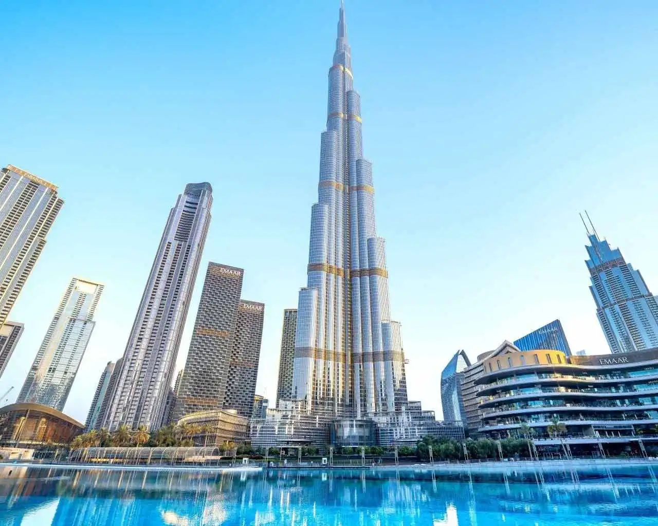 Burj Khalifa skyscraper towering over Downtown Dubai skyline with the Dubai Fountain lake in the foreground