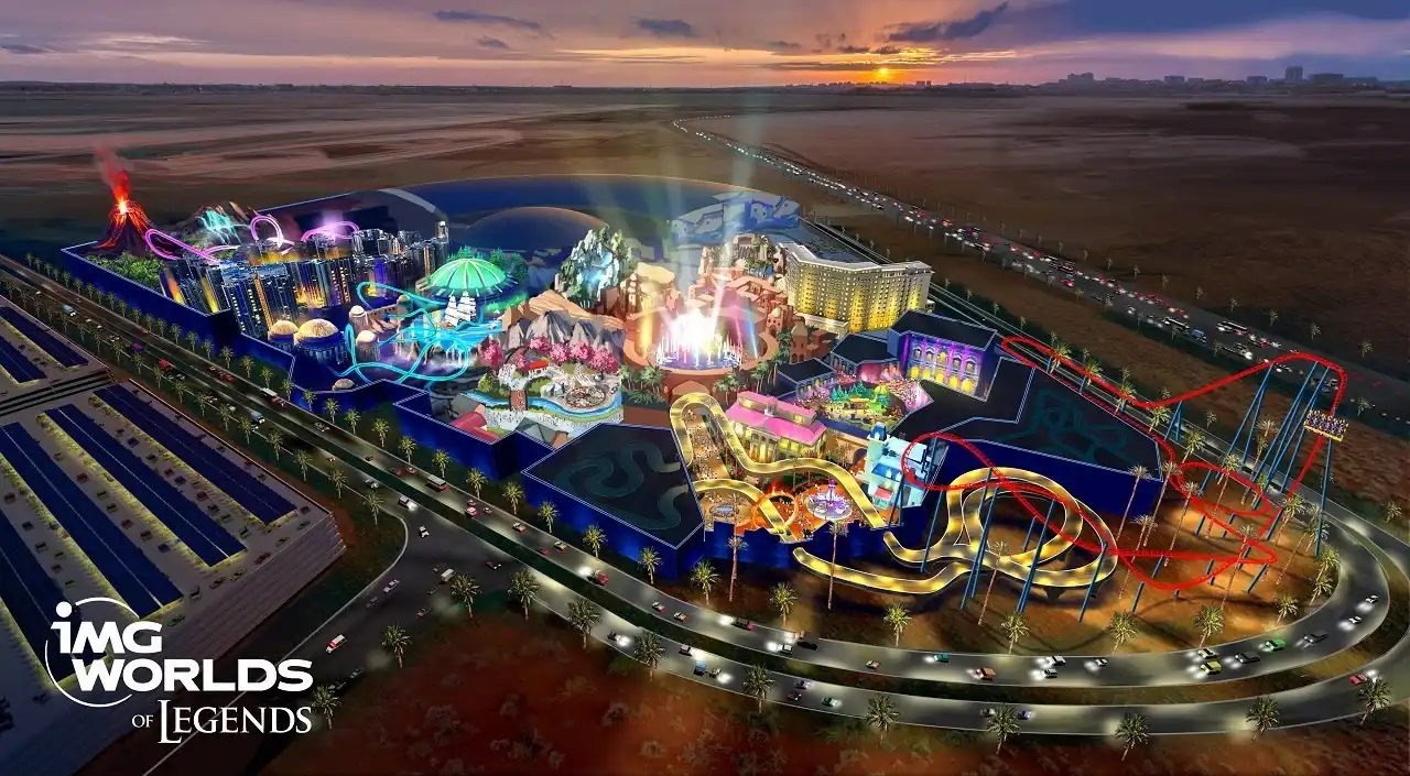 Aerial night view of IMG Worlds of Adventure theme park in Dubai showing illuminated rides, roller coasters, and attractions