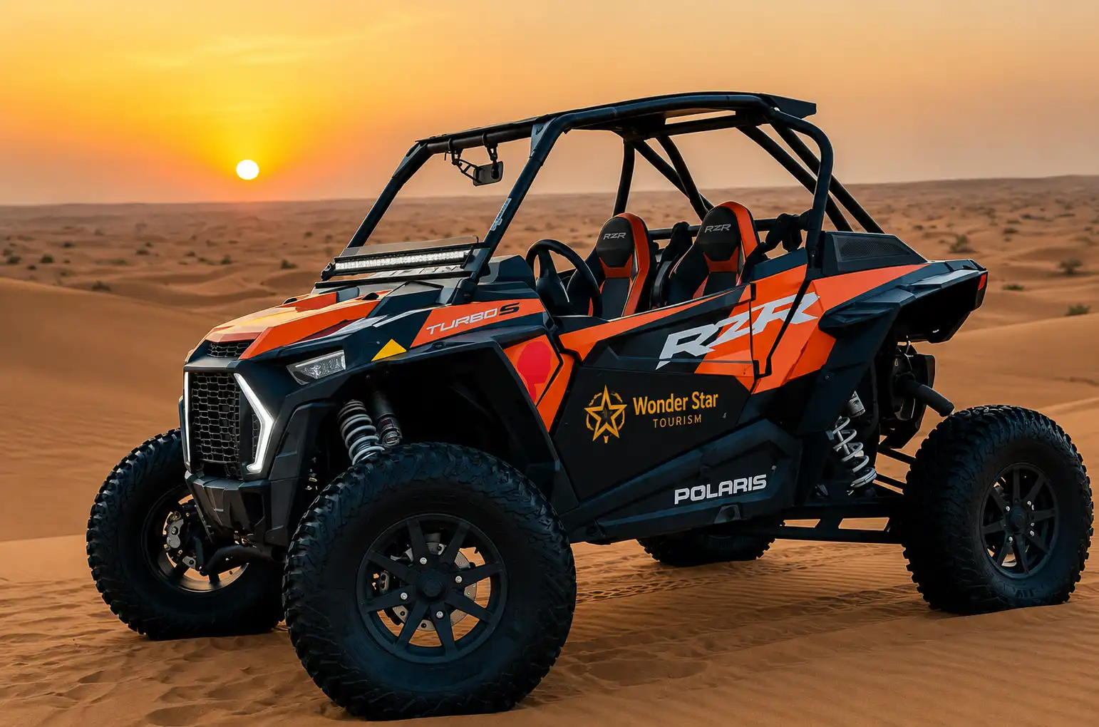 Black and orange Polaris RZR Turbo S off-road buggy with Wonder Star Tourism branding parked in the desert at sunset